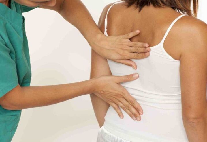 doctor examines the back with pain in the shoulder blade
